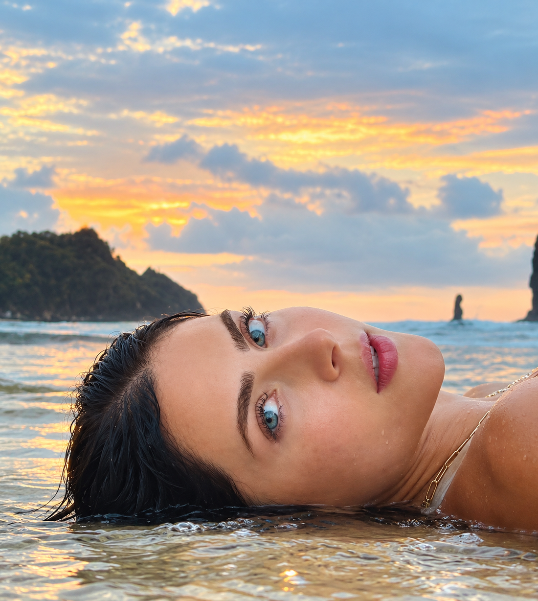 Woman lying in shallow water at sunset, how seasons affect your skin