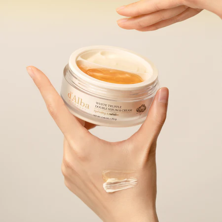 Hand holding a jar of dAlba White Truffle Double Serum & Cream with a visible swatch on the palm. Korean moisturizer for soft, hydrated skin, LUME